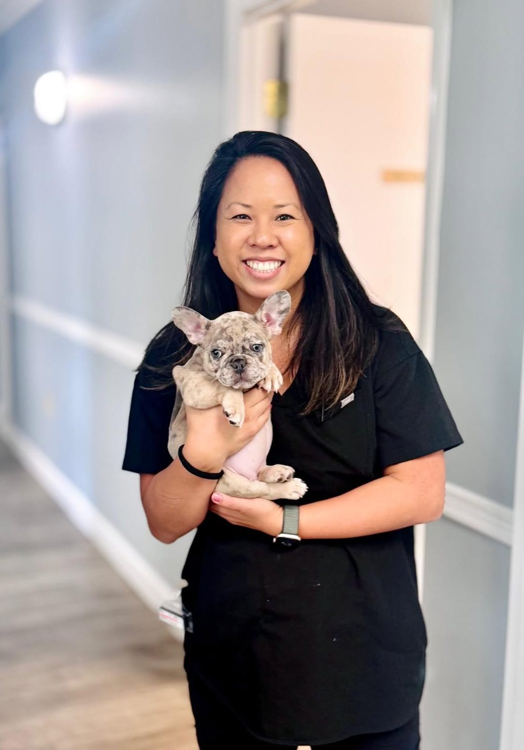 Medical Director Veterinarian holding puppy and smiling